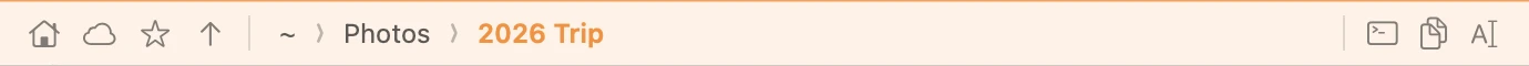 The address bar close up: home, iCloud Drive, bookmark and up buttons, then the breadcrumbs ~ › Photos › 2026 Trip, with open-in-terminal, copy-path and rename buttons on the right.